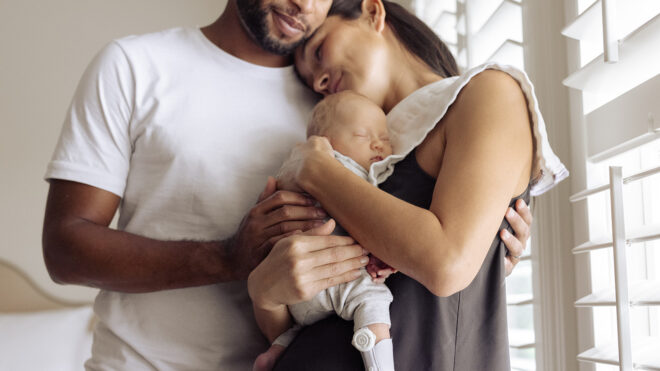 family in bedroom with new baby
