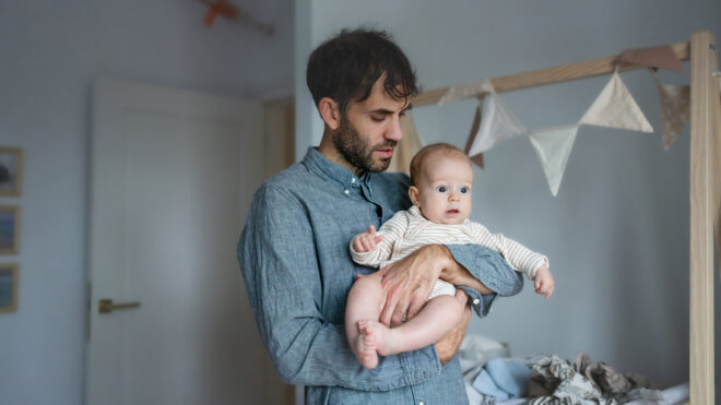 Dad holding baby in nursery