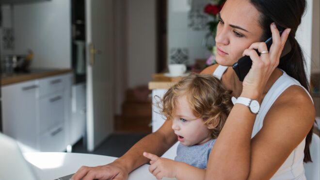 mom on phone with child on her lap