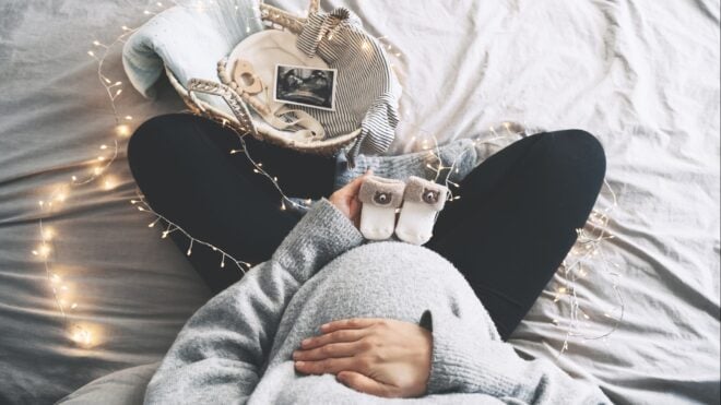 woman pregnant holding ultrasound photo