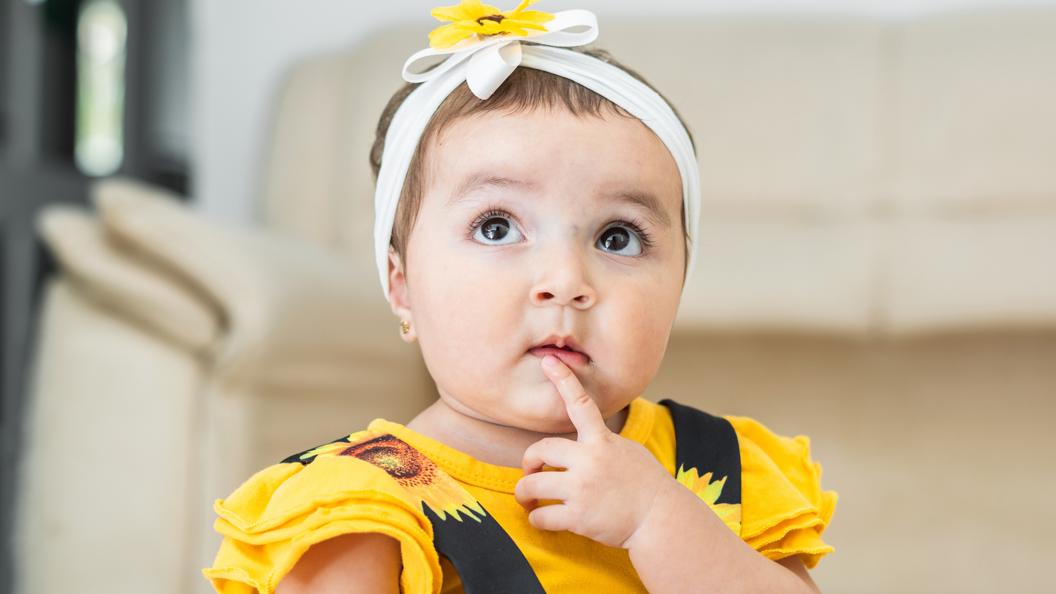 beautiful baby latina, looking up, with a thoughtful face, searching for ideas.
