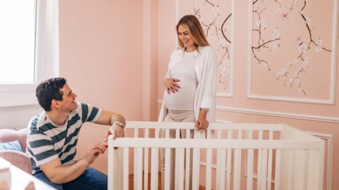 Husband and his pregnant wife prepare for the arrival of the baby, assemble the crib and decorate the baby's room