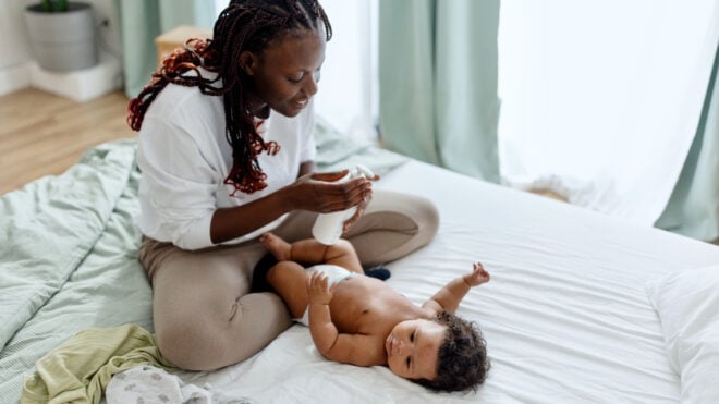 health and wellness essentials, Mother putting dy lotion on her baby boy