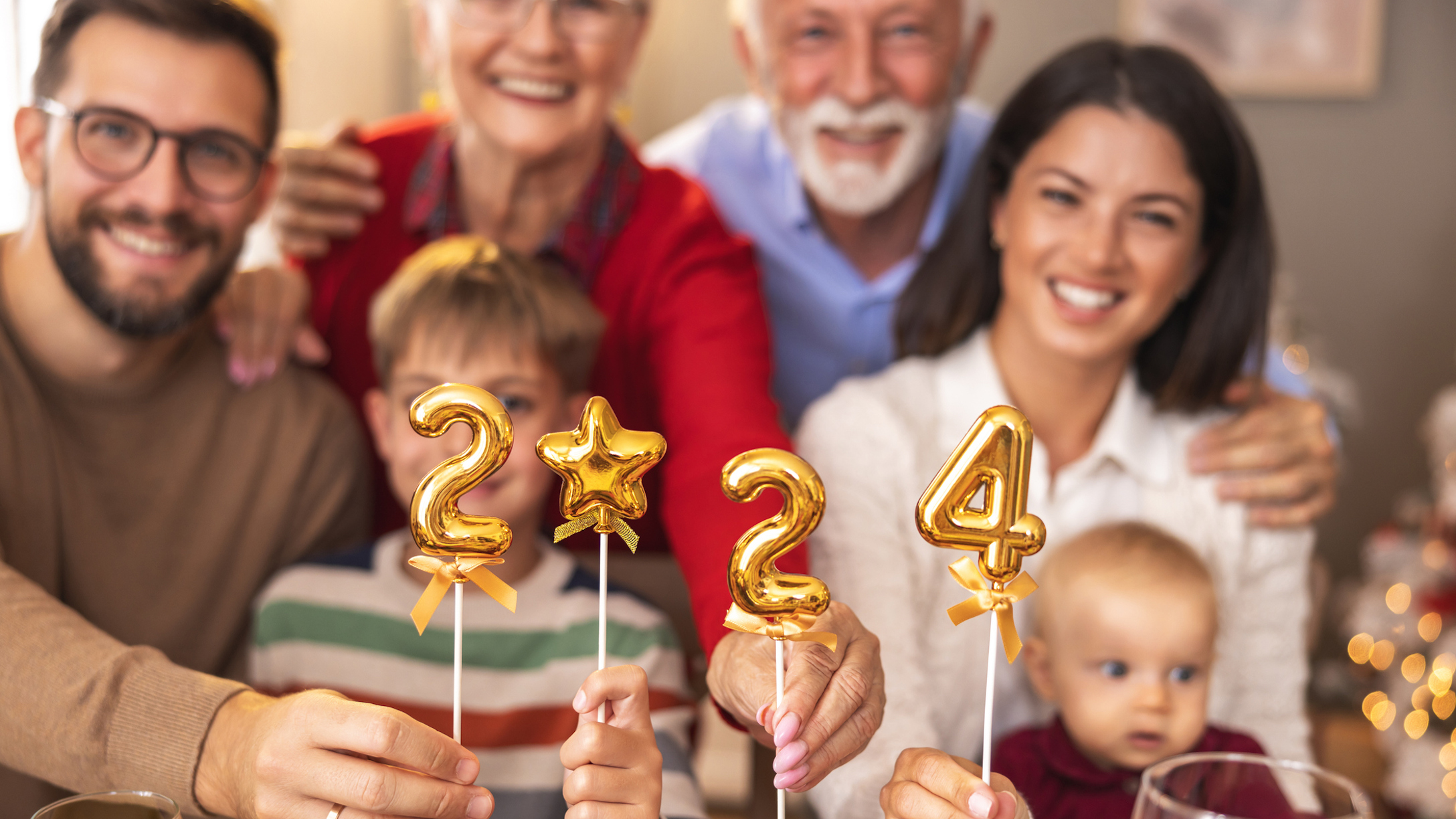 Family holding balloons shaped as numbers 2024