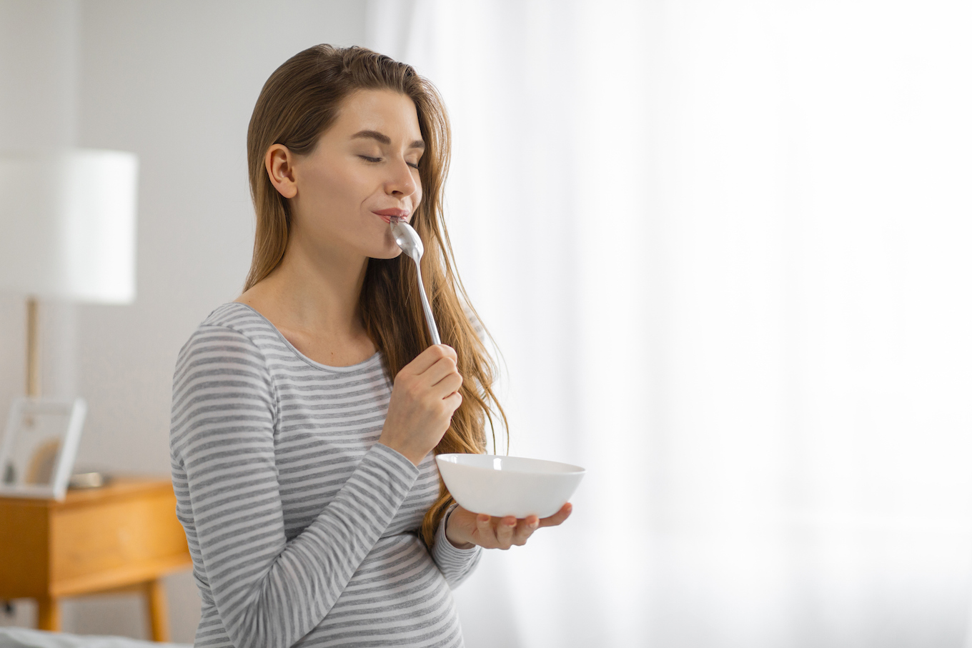 Pregnant woman eating from a bowl