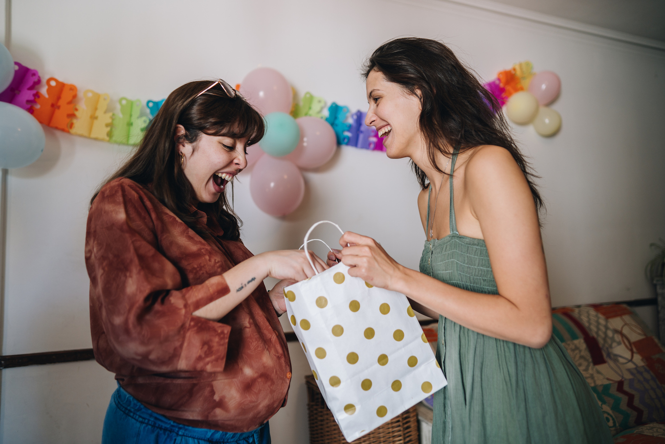 Friend giving a gift to her pregnant friend