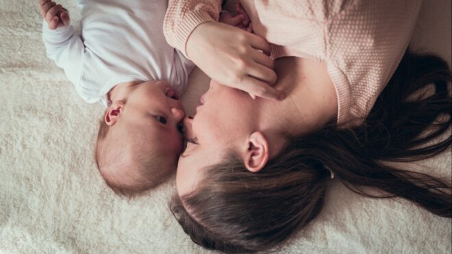 A woman lying with a baby