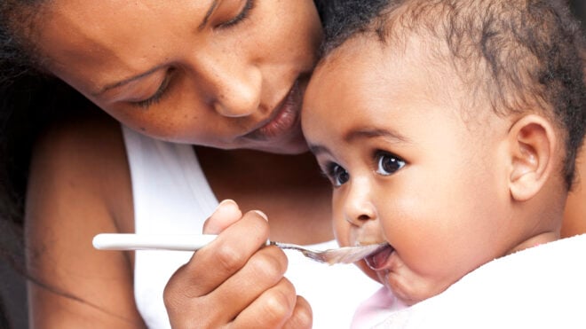 Mom feeding baby solid food