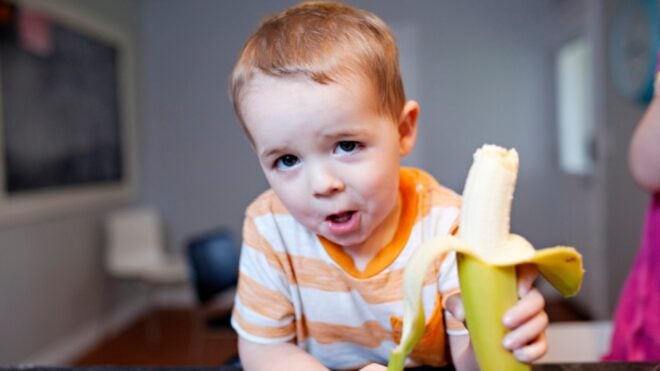 Toddler eating a banana